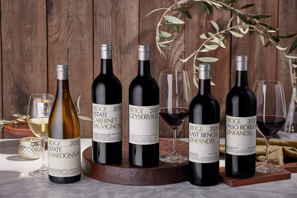 Collection of Ridge Vineyards wine bottles and glasses on a wooden table with a rustic background