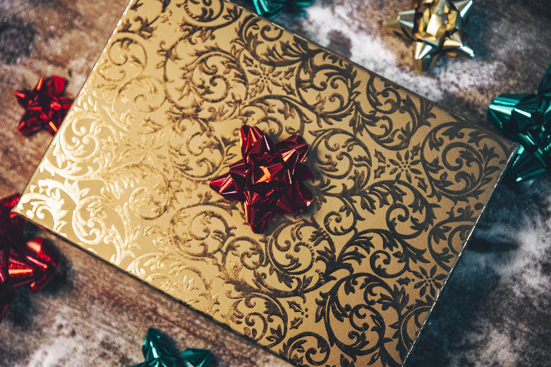 Gold-wrapped gift box with red bow