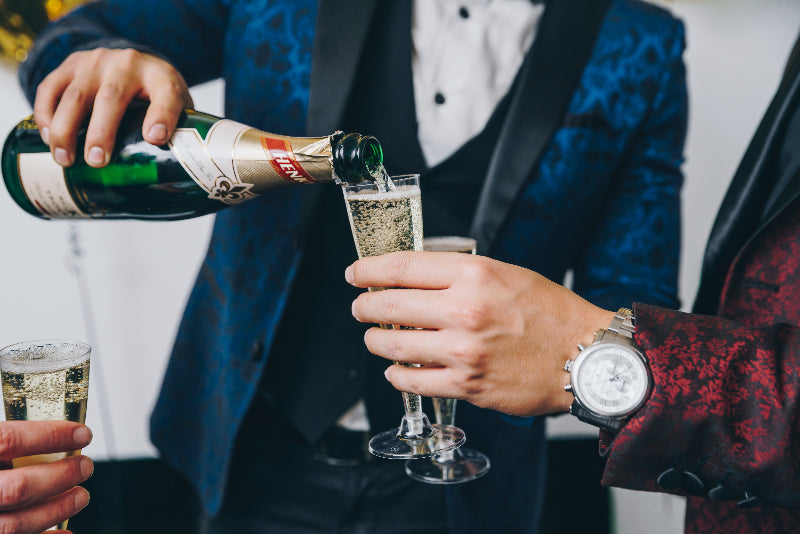 People in suits pouring sparkling wine